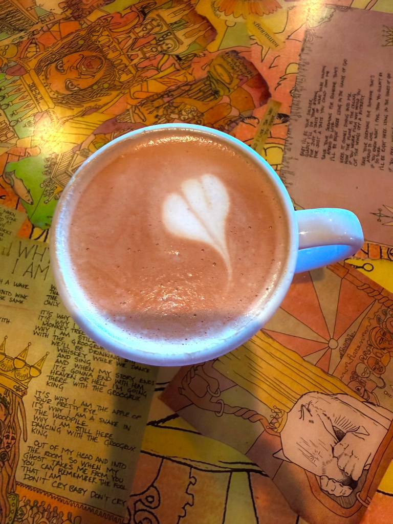 aromatic cup of coffee with milk, most likely capuccino has a hear shaped foam